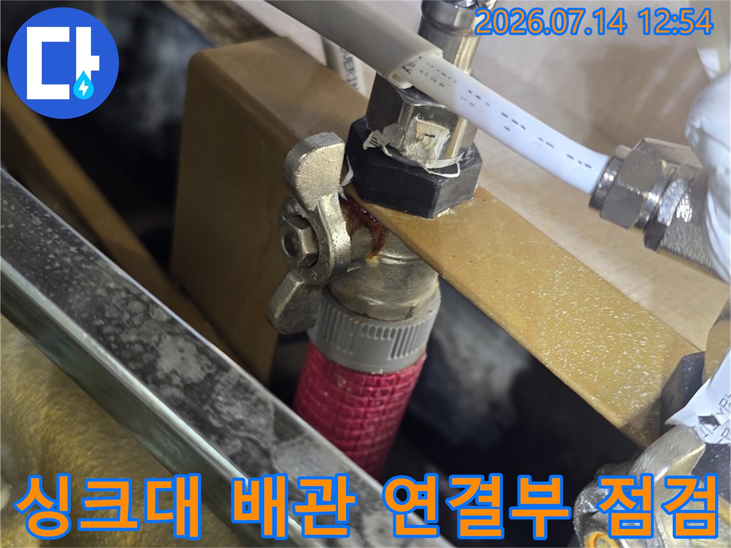 싱크대 하부의 노출된 급수 및 온수 배관 연결 부위 점검 모습