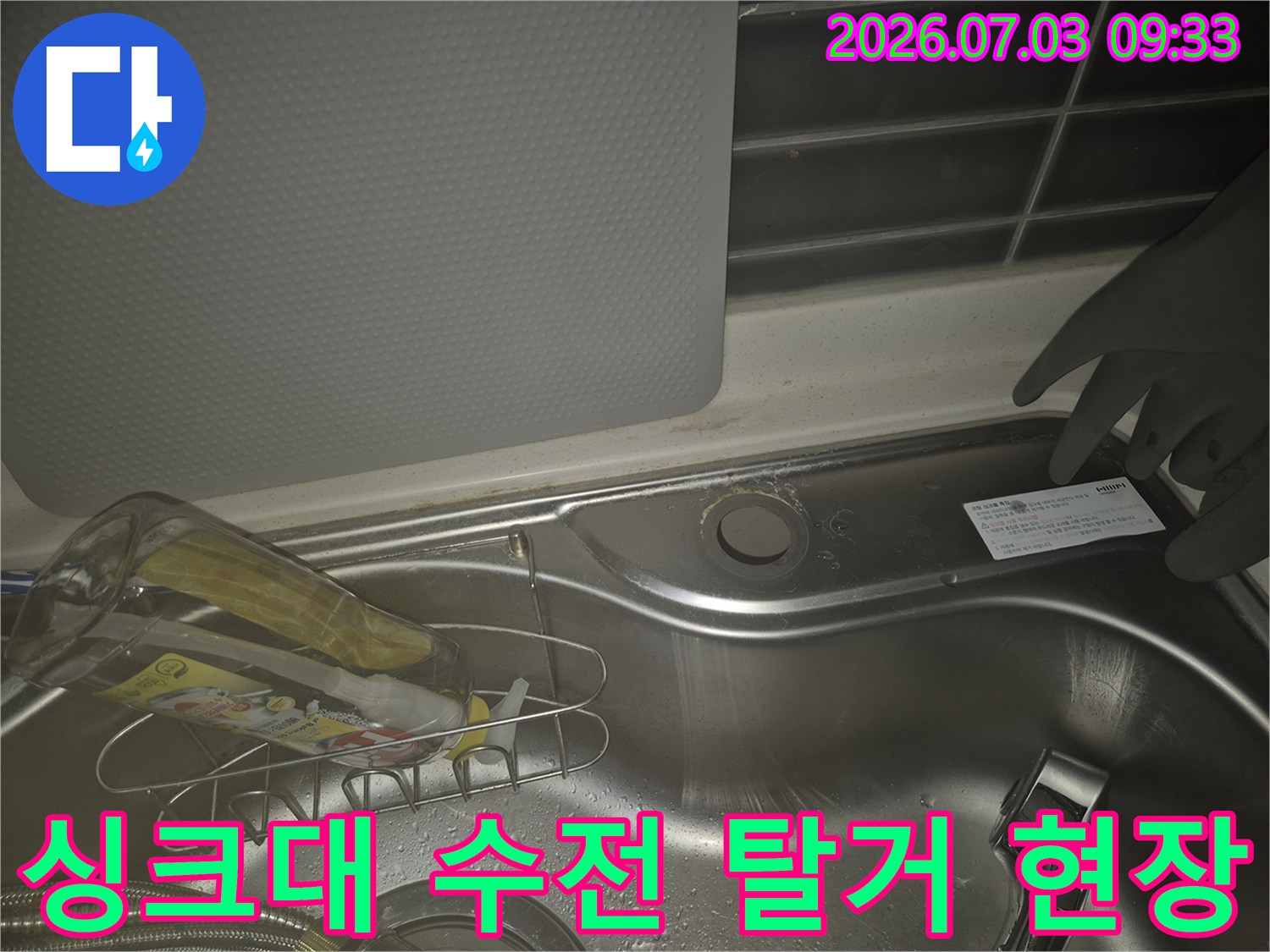 싱크대 배수구 근처에 위치한 수전을 탈거하고 작업 준비를 하는 모습
