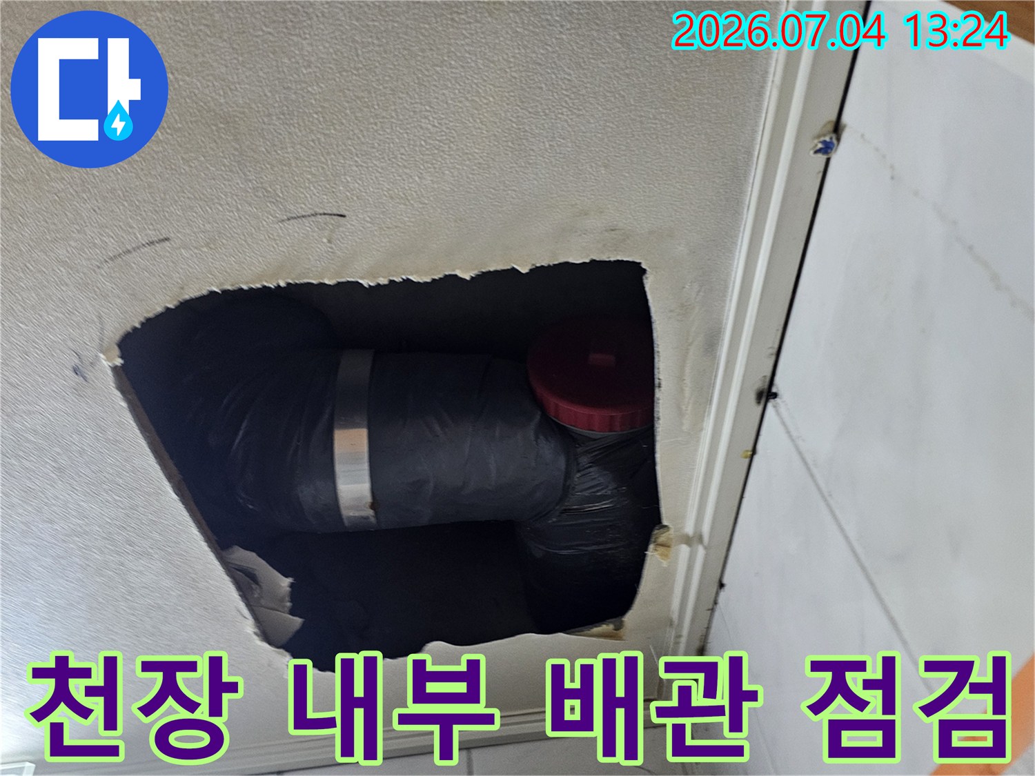천장 점검구를 통해 확인한 검은색 보온재로 감싸인 배관과 소방용 밸브 구조물