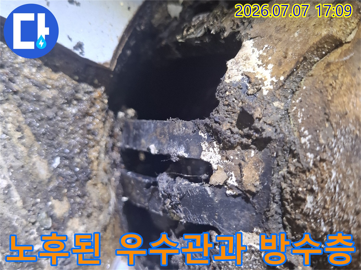 누수가 발생한 우수관 주변의 손상된 마감재를 근접 촬영한 모습