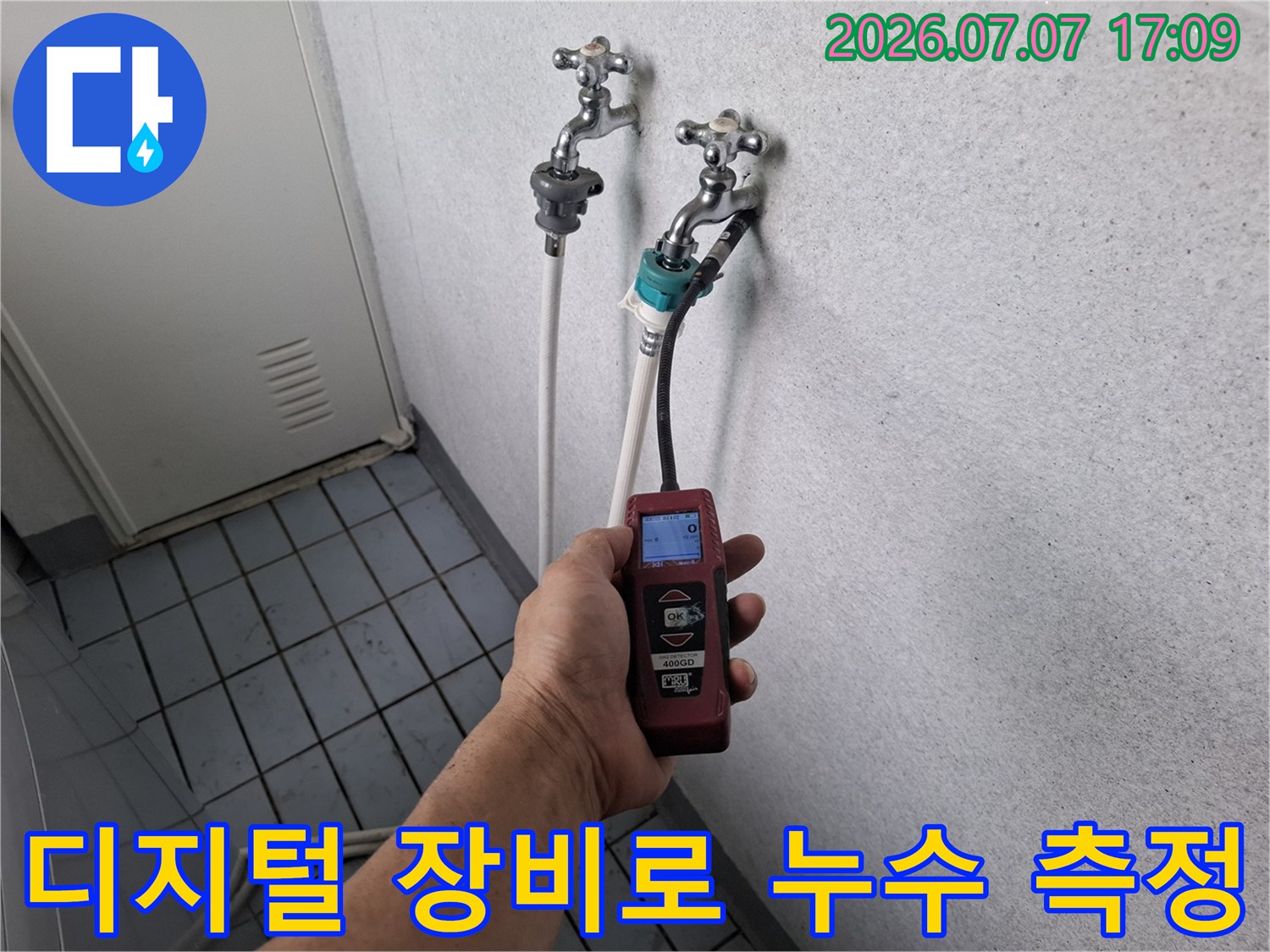 전문가용 수치 표시 탐지기를 활용하여 베란다 배관의 상태를 정밀하게 검측하는 모습