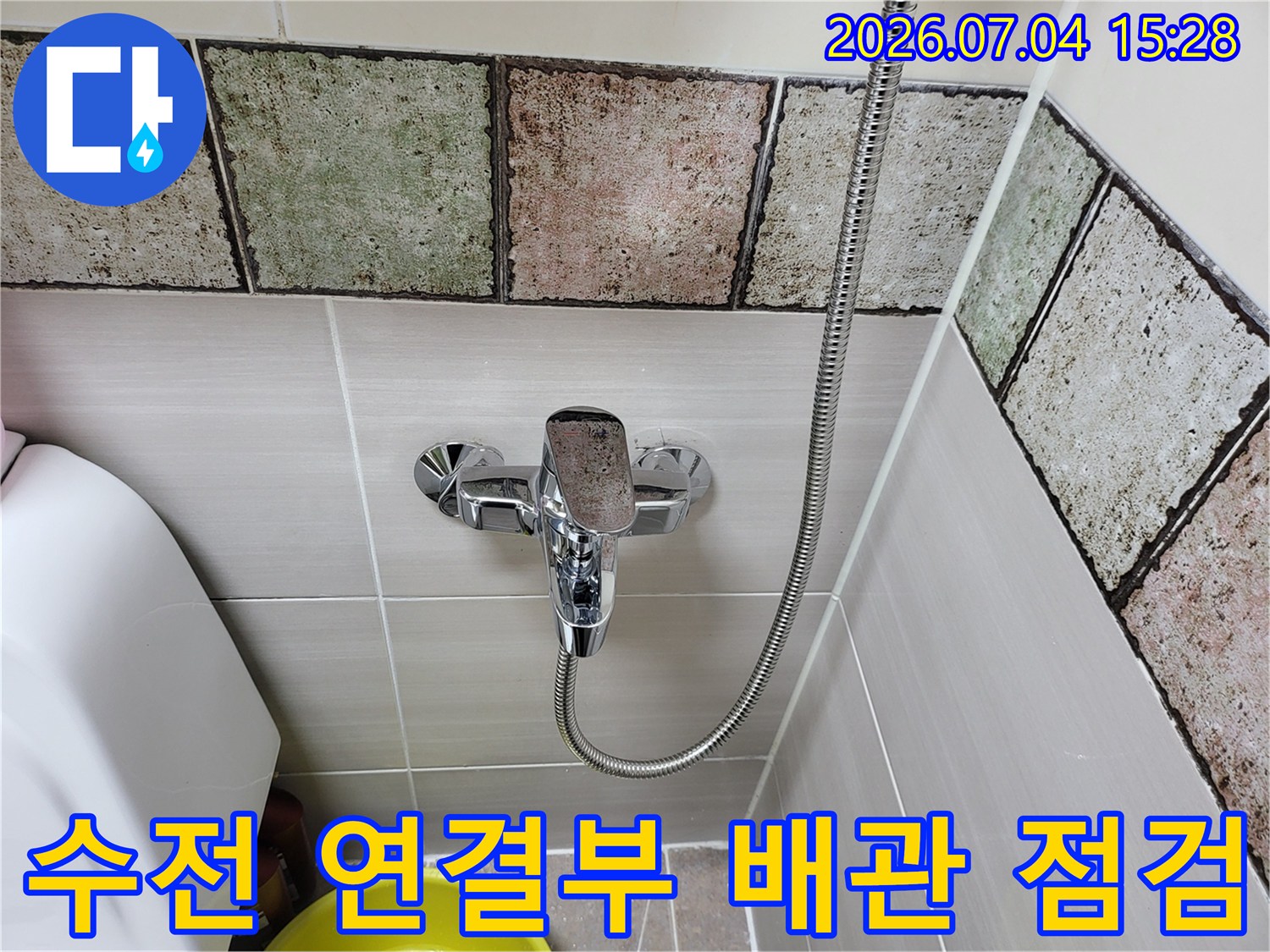 욕실 타일 벽면과 샤워기 수전이 결합된 구간의 상세 촬영