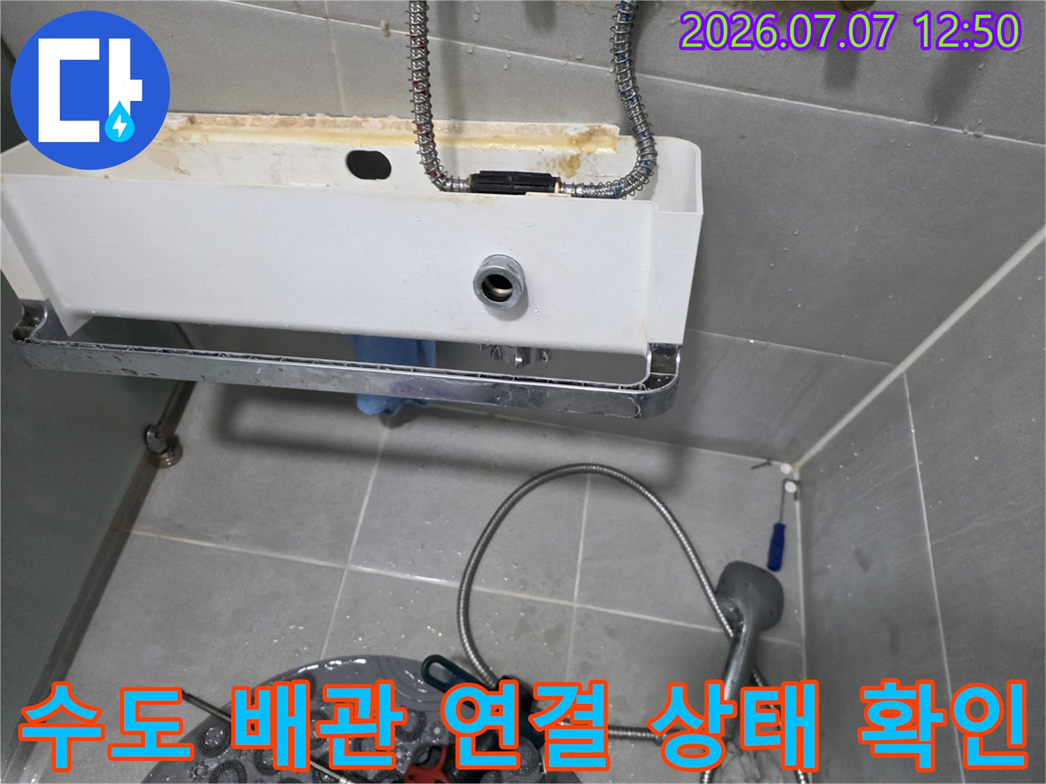 세면대 아래쪽으로 노출된 고압호스와 수도 밸브 쪽의 누수 여부를 점검하는 장면