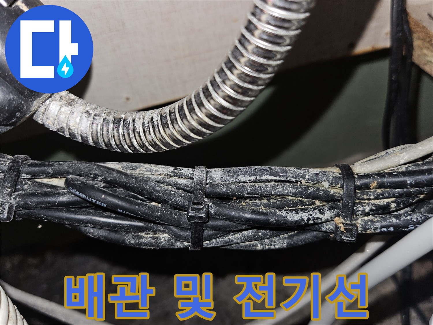 천장 내부의 은색 주름관과 검은 전선 뭉치 모습