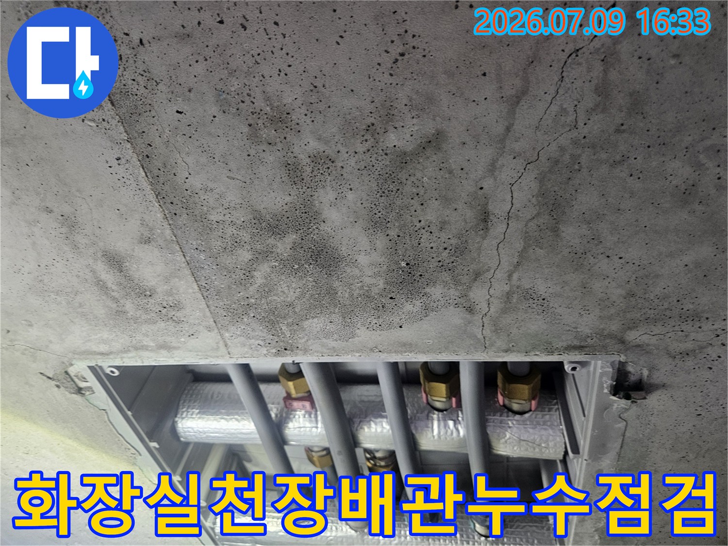 화장실 천장 콘크리트 균열과 노출된 배관 시스템 점검 모습
