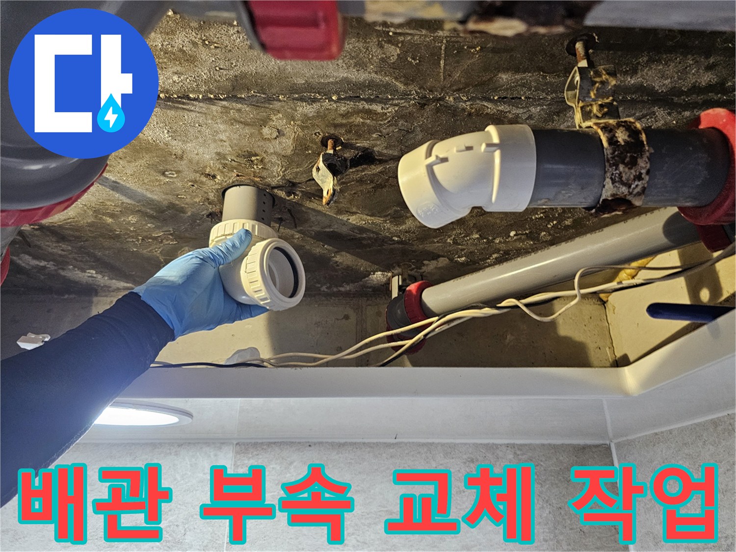 화장실 천장 내부의 노후된 배관 부속을 새로운 자재로 교체하는 모습입니다.