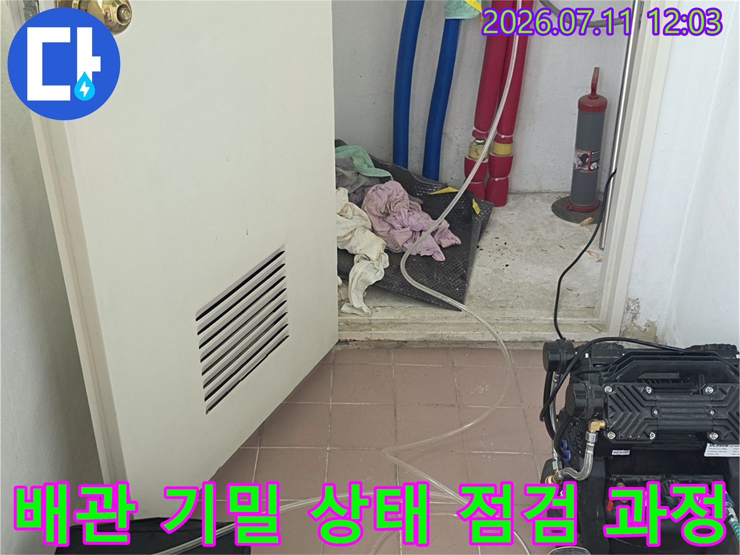 보일러실 내 여러 색상의 배관에 공압 측정기를 연결하여 누수 여부를 진단하는 장면