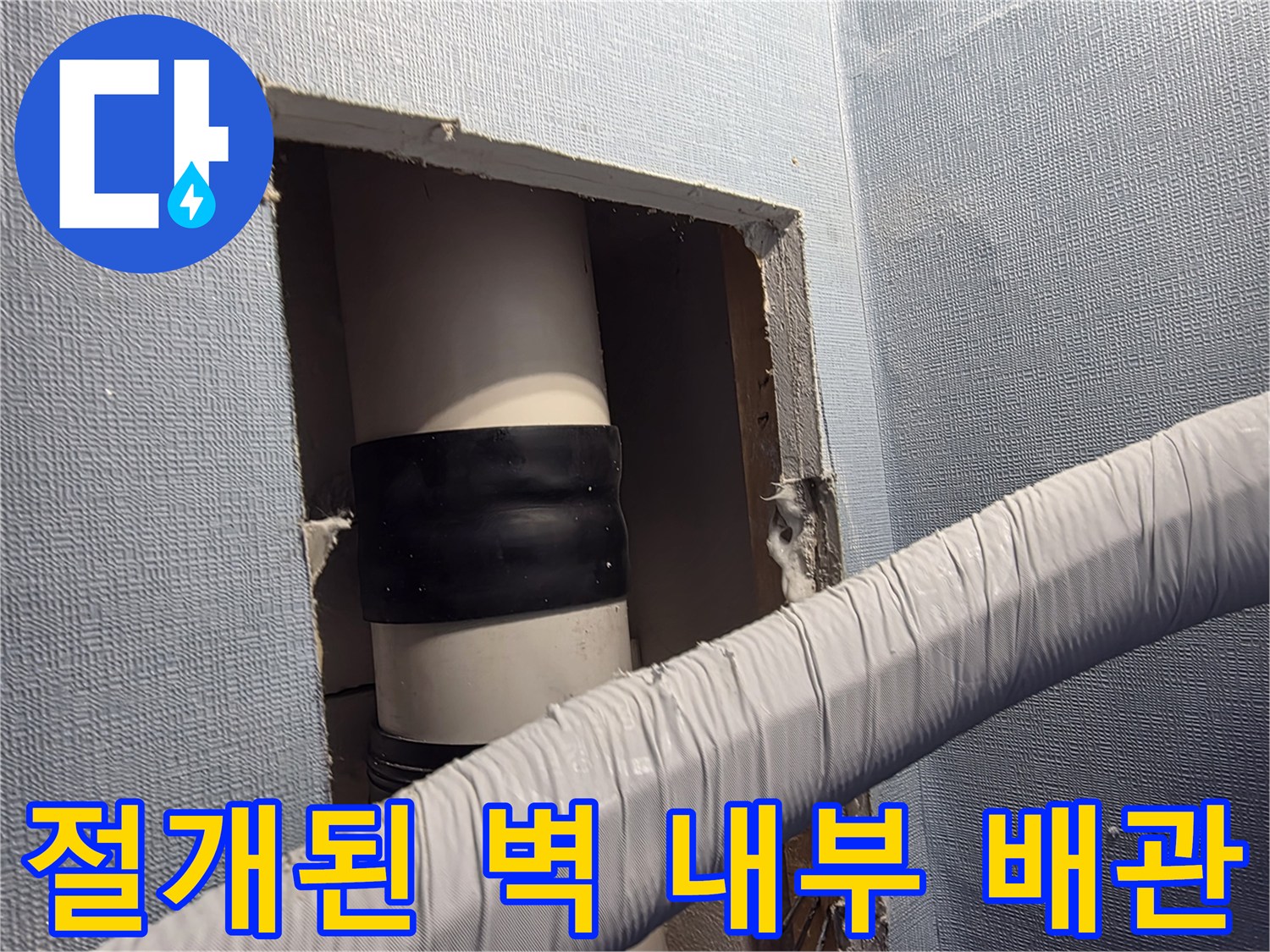 벽면을 뜯어내어 드러난 하얀색 배관과 보수용 검은 밴드 부위