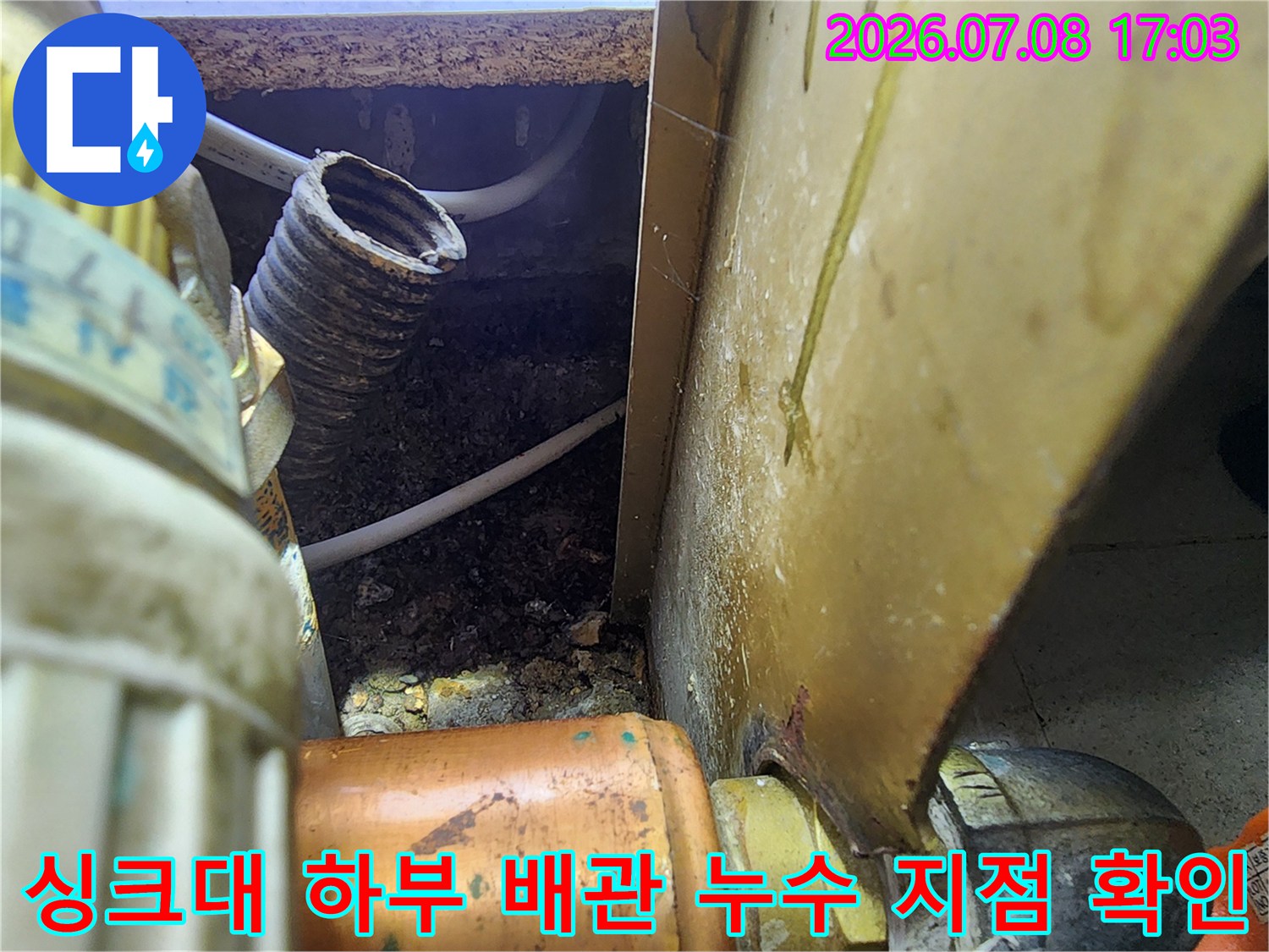 싱크대 아래쪽 구석에 위치한 노출 배관과 연결 부위의 누수 상태 점검 모습