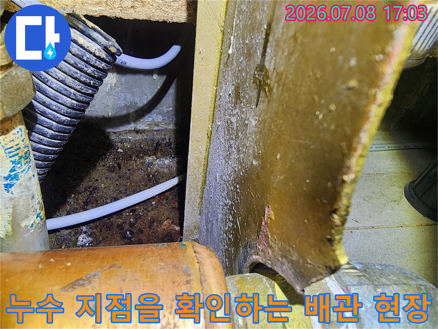 싱크대 하부 공간 내의 노출된 배관과 주변 습기 흔적을 촬영한 모습