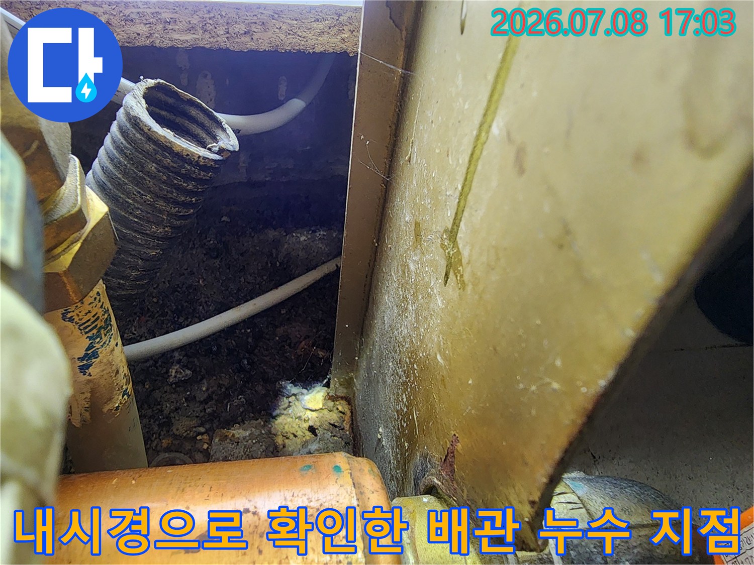 싱크대 하부 공간에서 내시경 장비를 이용해 배관 연결 부위의 누수를 점검하는 모습