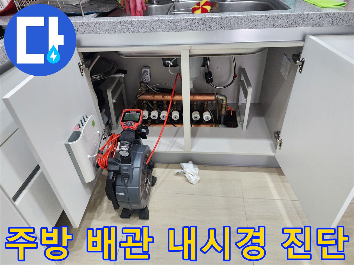 싱크대 하부장 내부의 배관 구조와 내시경 장비 운용 모습
