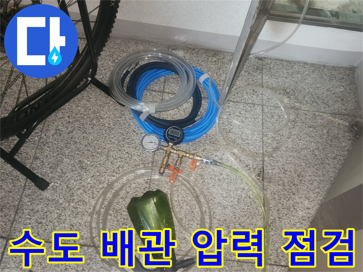 배관 누수 진단을 위해 세팅된 디지털 게이지와 연결 호스 뭉치