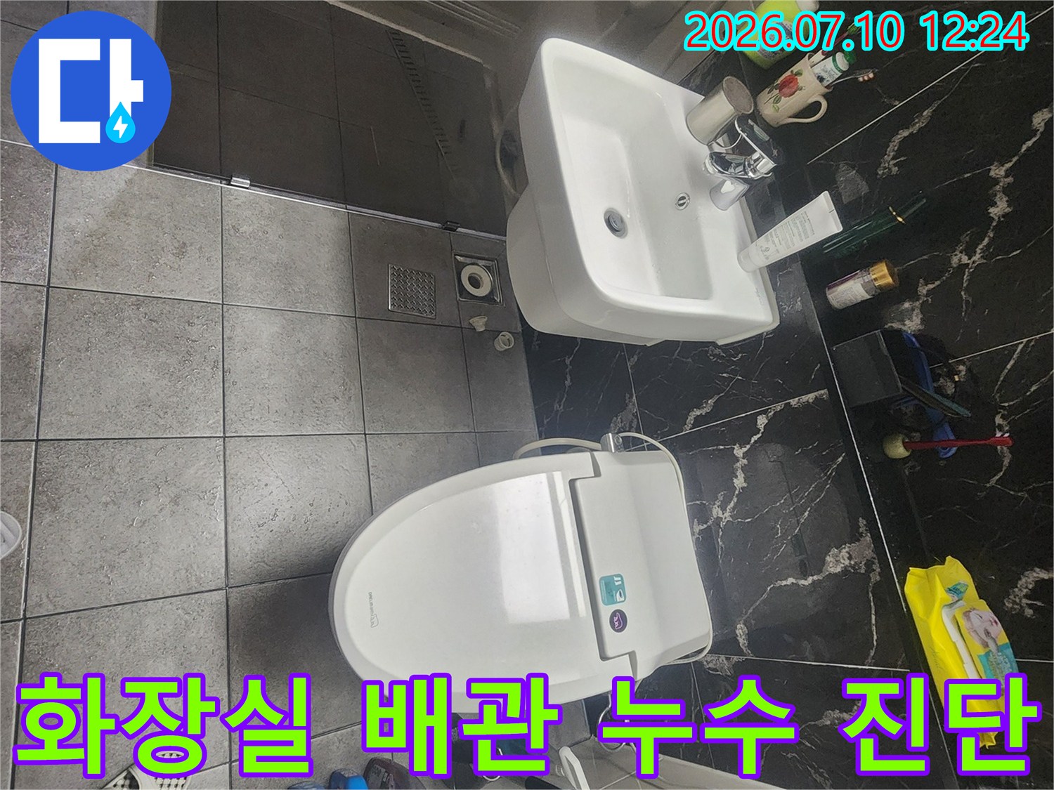 화장실 세면대와 양변기 주변에 배치된 누수 정밀 점검 장비들