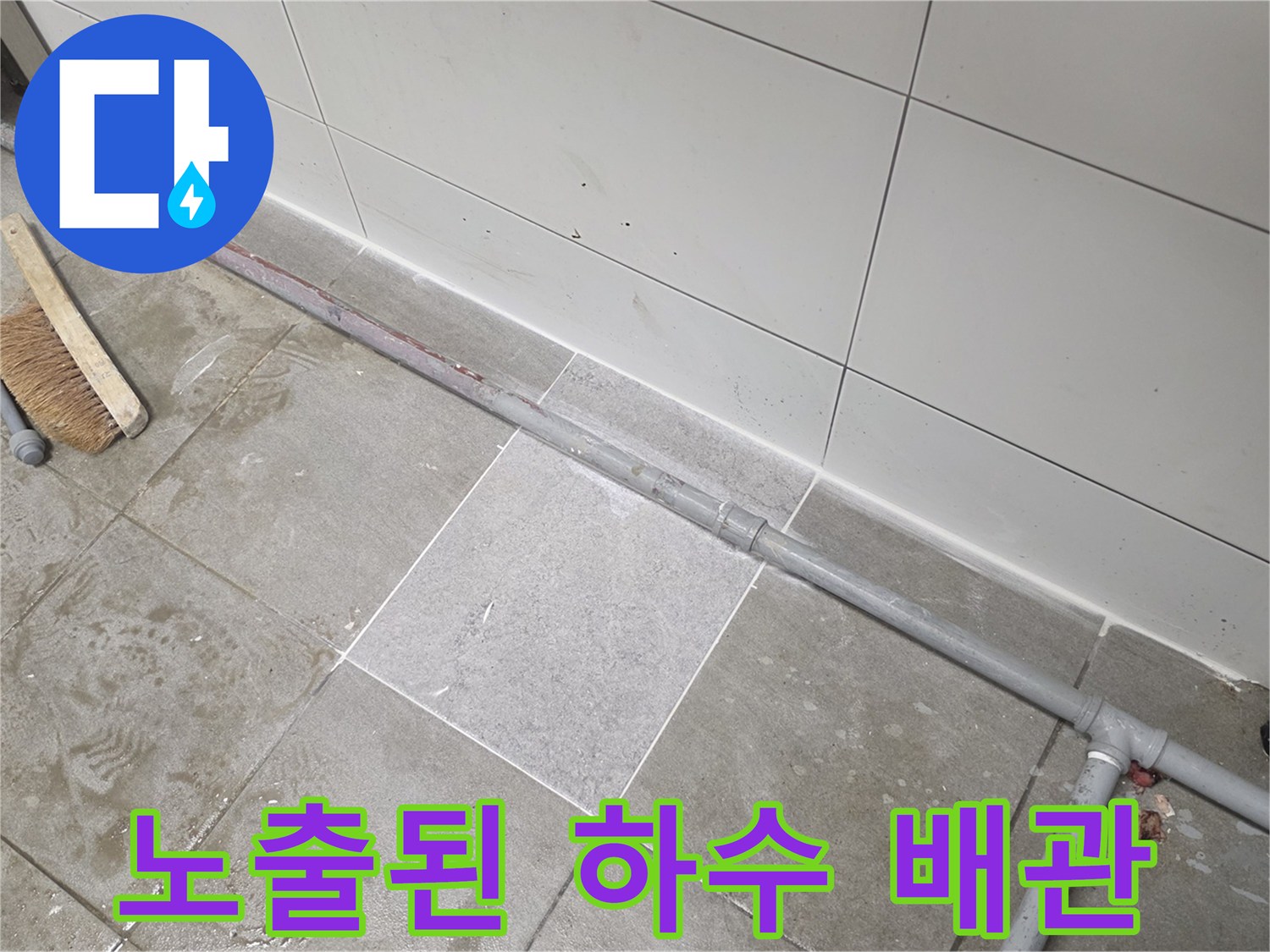 하얀-벽면-타일-아래로-보이는-회색-PVC-배수관