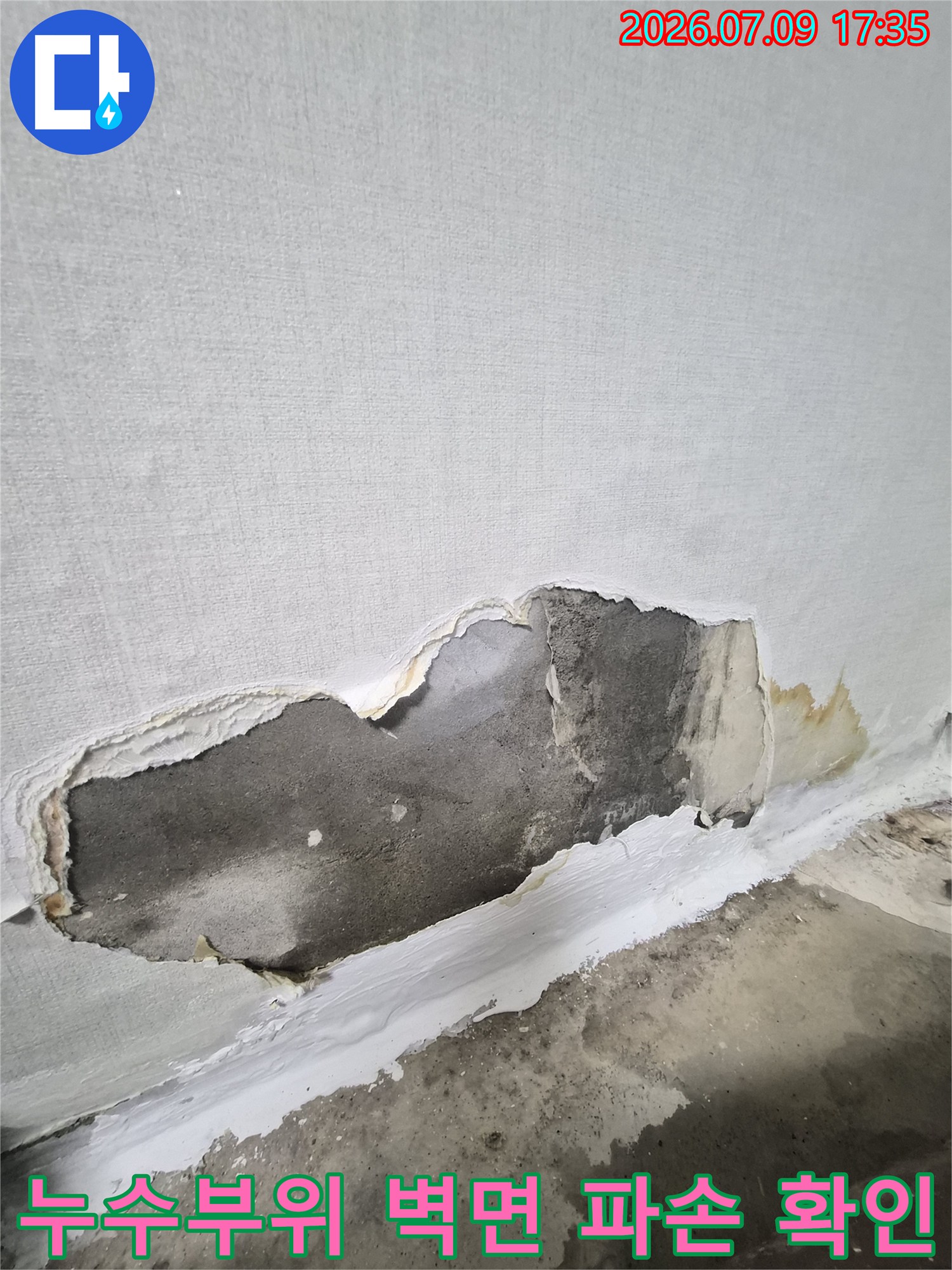 벽면 마감재를 제거하고 노출된 배관 주변의 손상 부위를 점검하는 모습