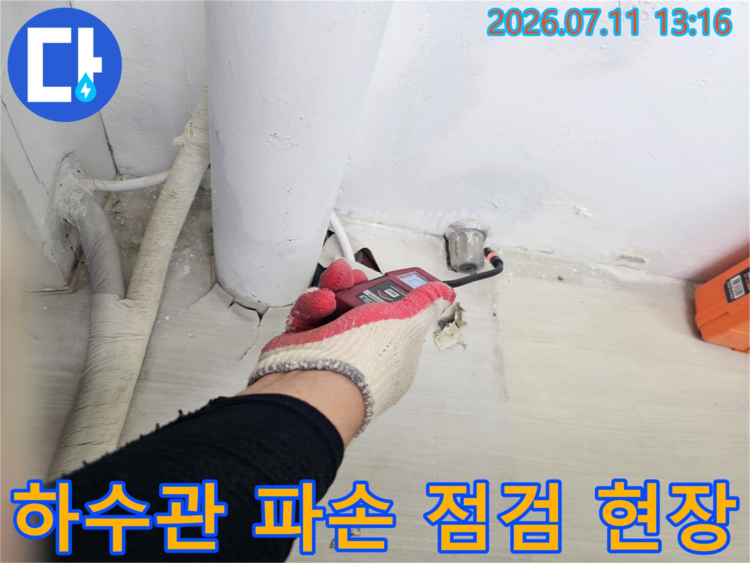 작업자가 장갑을 낀 채로 렌치를 사용하여 노출된 배관 연결부를 체크하는 모습