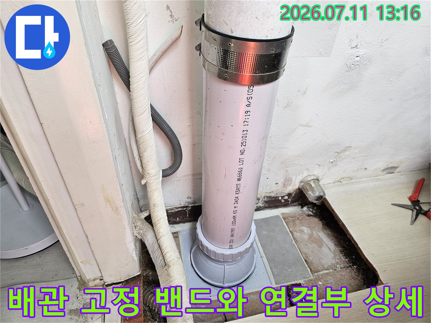 흰색 배관과 금속 고정 장치가 결합된 형태의 실제 작업 현장 사진