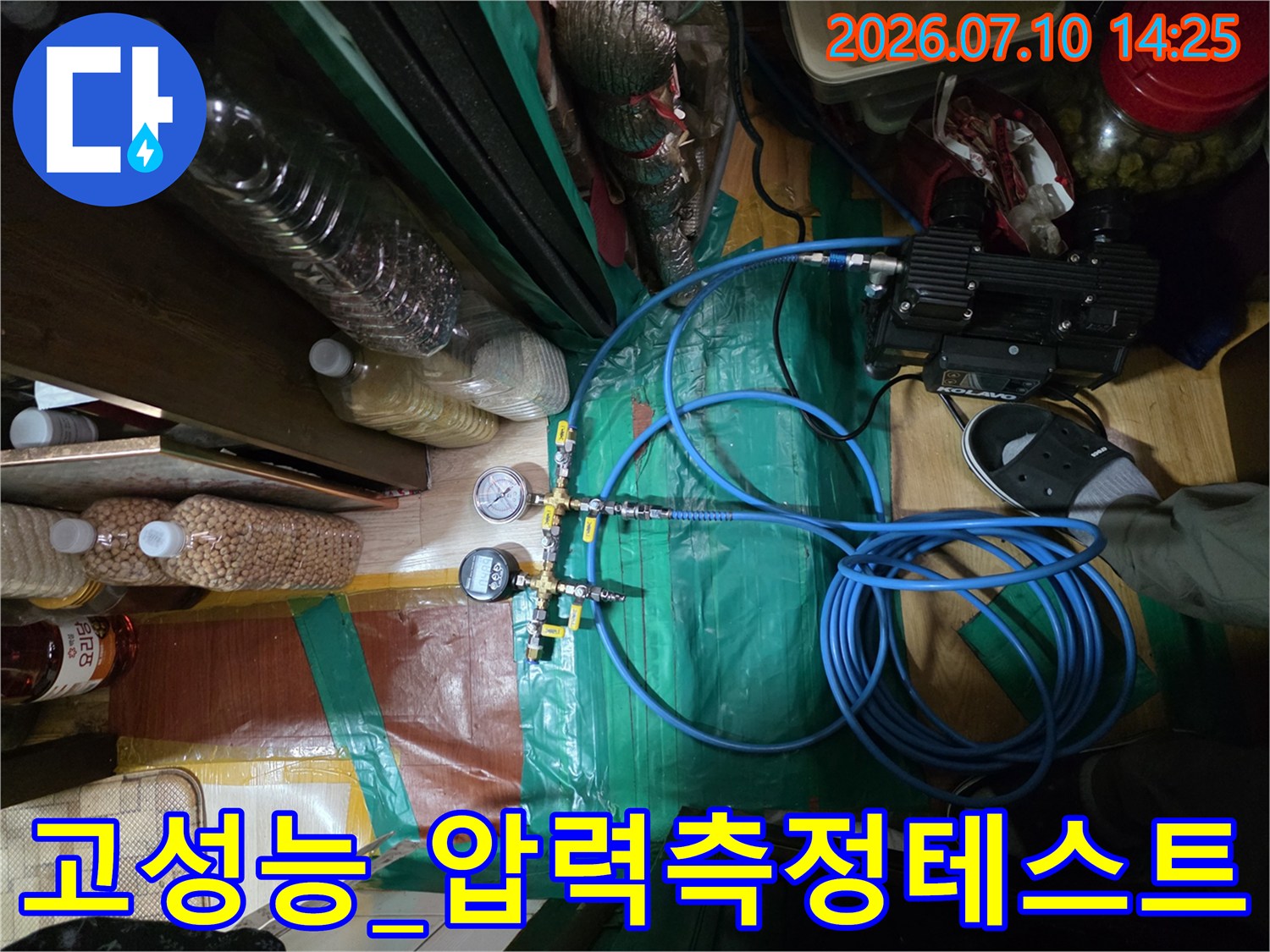 전문 장비와 파란색 호스를 이용한 배관 압력 체크 과정
