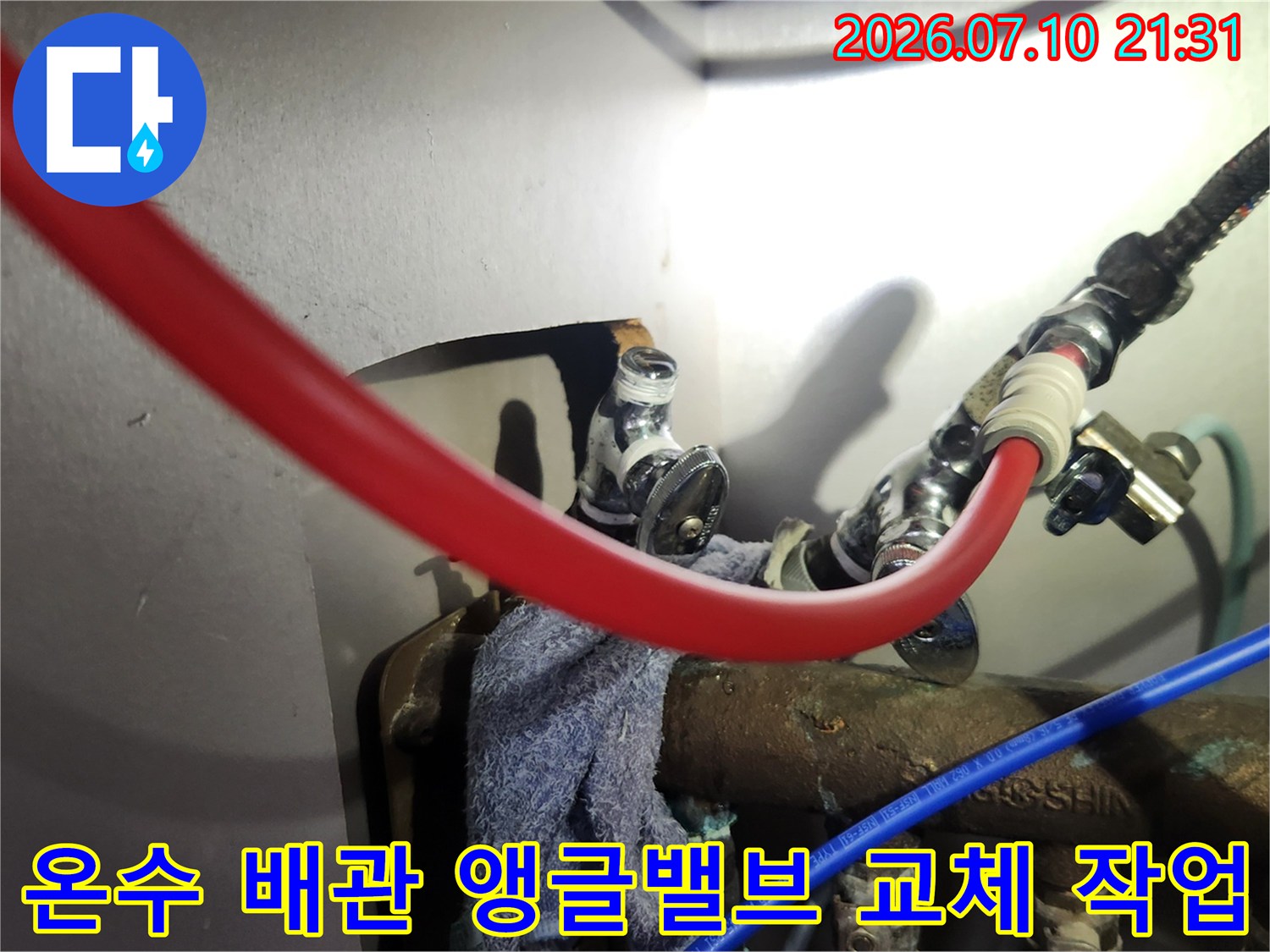 새로운 온수 호스와 엘보우 부속을 연결한 배관 수리 현장