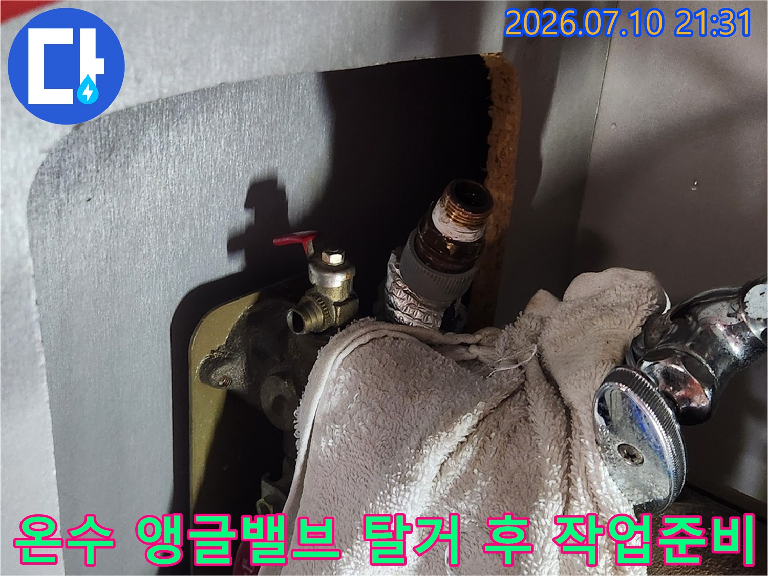 싱크대 하부의 온수 배관에서 낡은 밸브를 제거하고 수리를 준비하는 모습