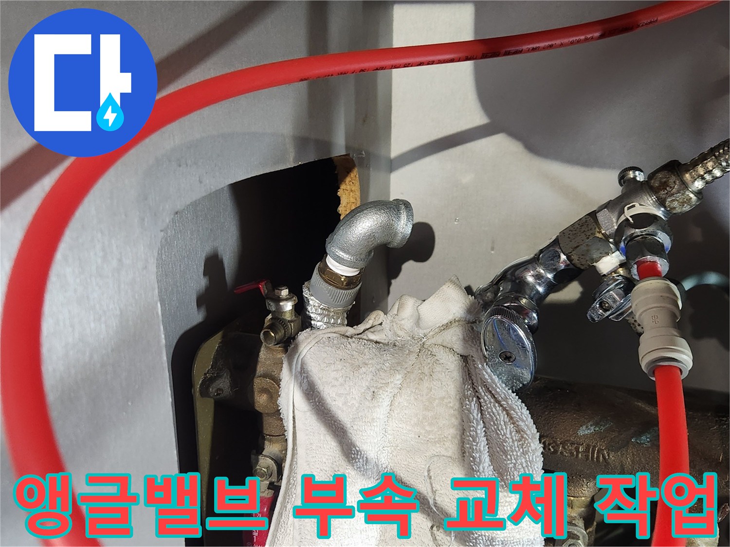 싱크대 하부장 내 앵글밸브와 엘보우 부속 설치 상태를 보여주는 사진입니다.
