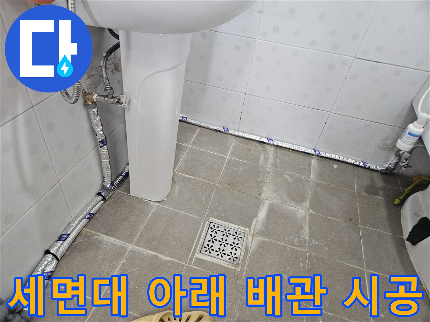 세면기 하단부 수도 연결을 위해 신설된 보온재 입힌 배관 상태