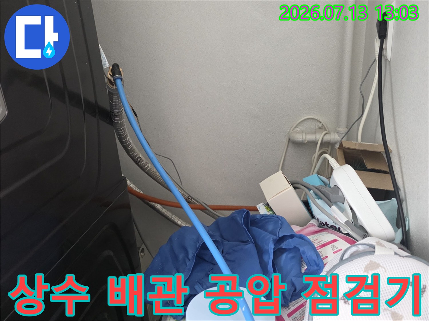 공압 장비와 파란색 호스로 연결된 배관 점검 장면