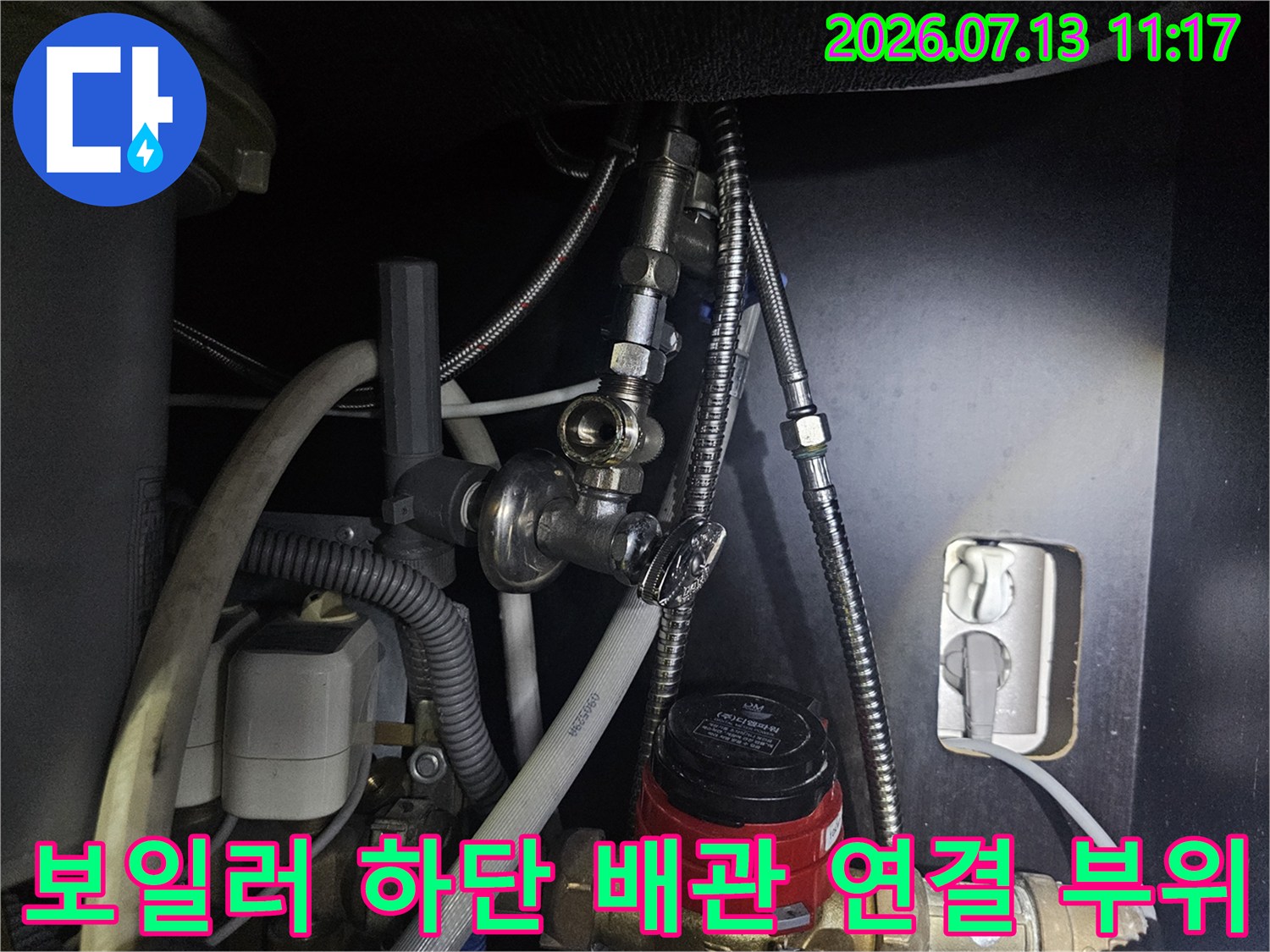 보일러 아래쪽에 설치된 스테인리스 주름관과 밸브-연결 부위를 점검하는 모습