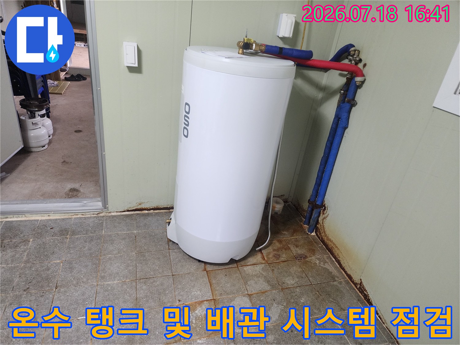 흰색 온수탱크와 파란-빨간 배관망의 누수 부위 보강 작업