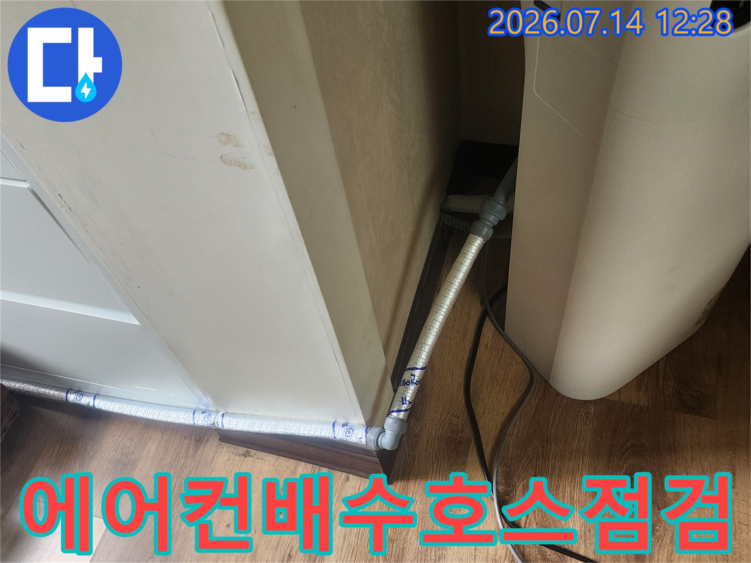 금속 재질의 에어컨 드레인 배수 호스가 베란다 천장 아래로 연결된 모습