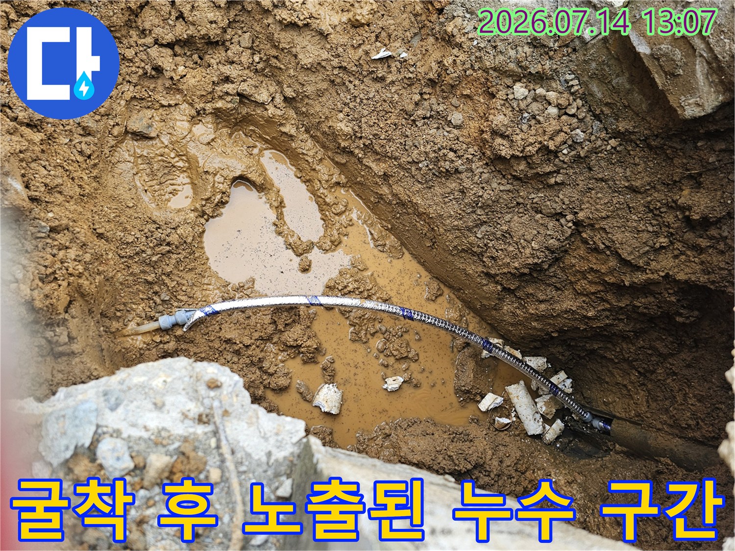 흙을 파내고 드러난 젖은 토양과 파란색 배관의 상세 모습