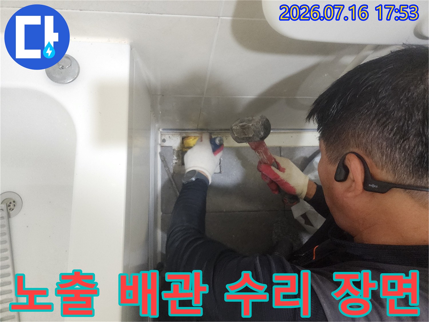 전문가가 장갑을 착용하고 화장실 하단부 배관을 공구로 견고하게 고정하는 모습