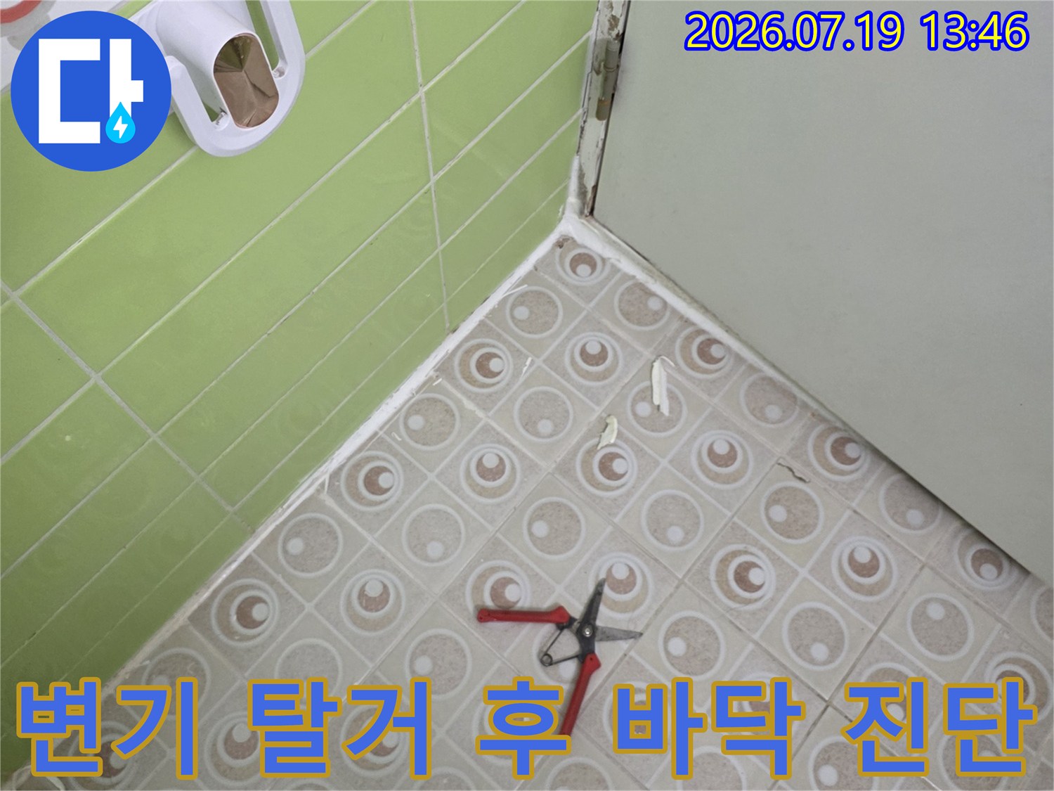 연두색 욕실 타일 위에-놓인 변기 부품과 작업용 가위 사진