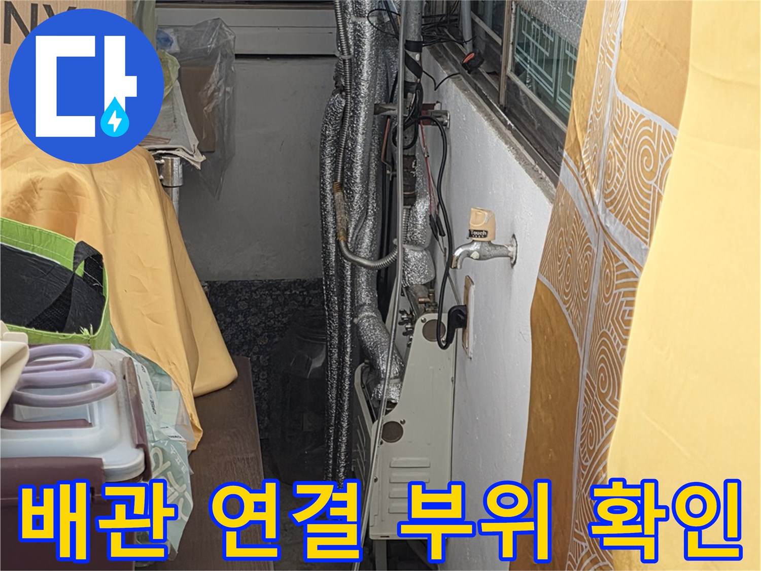 보온재로 덮여있는 수도 배관의 연결 부위를 집중적으로 점검하는 장면입니다.