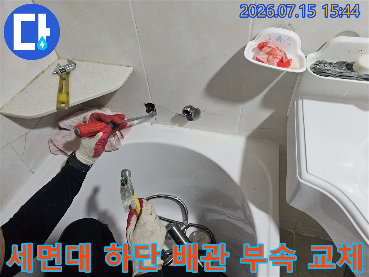 기술자가 세면대 밑으로 들어가 노후된 수도 배관을 정밀하게 작업하는 모습
