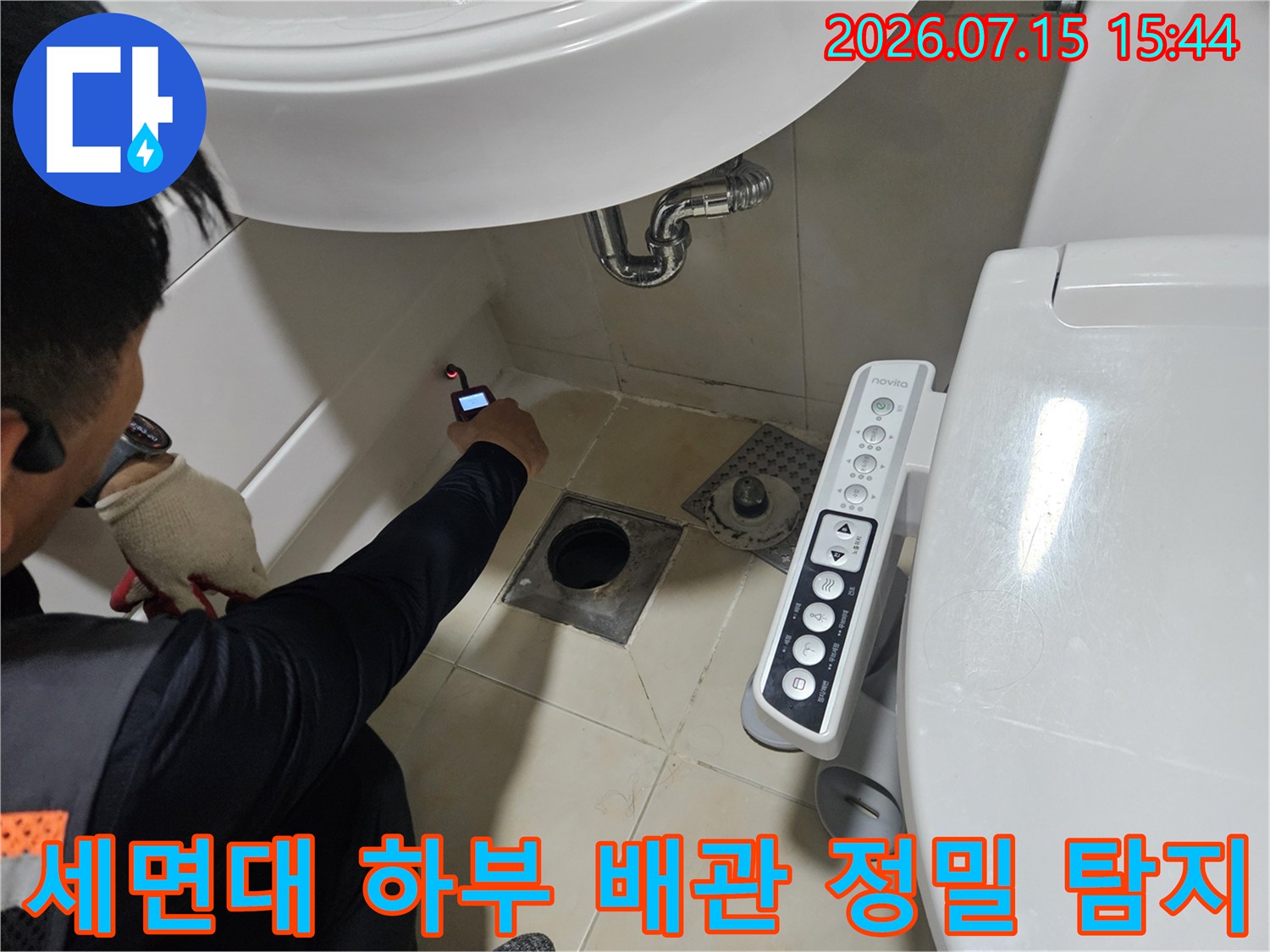 배관 누수 지점을 찾기 위해 세면대 밑에서 청음식 장비를 조작하는 모습
