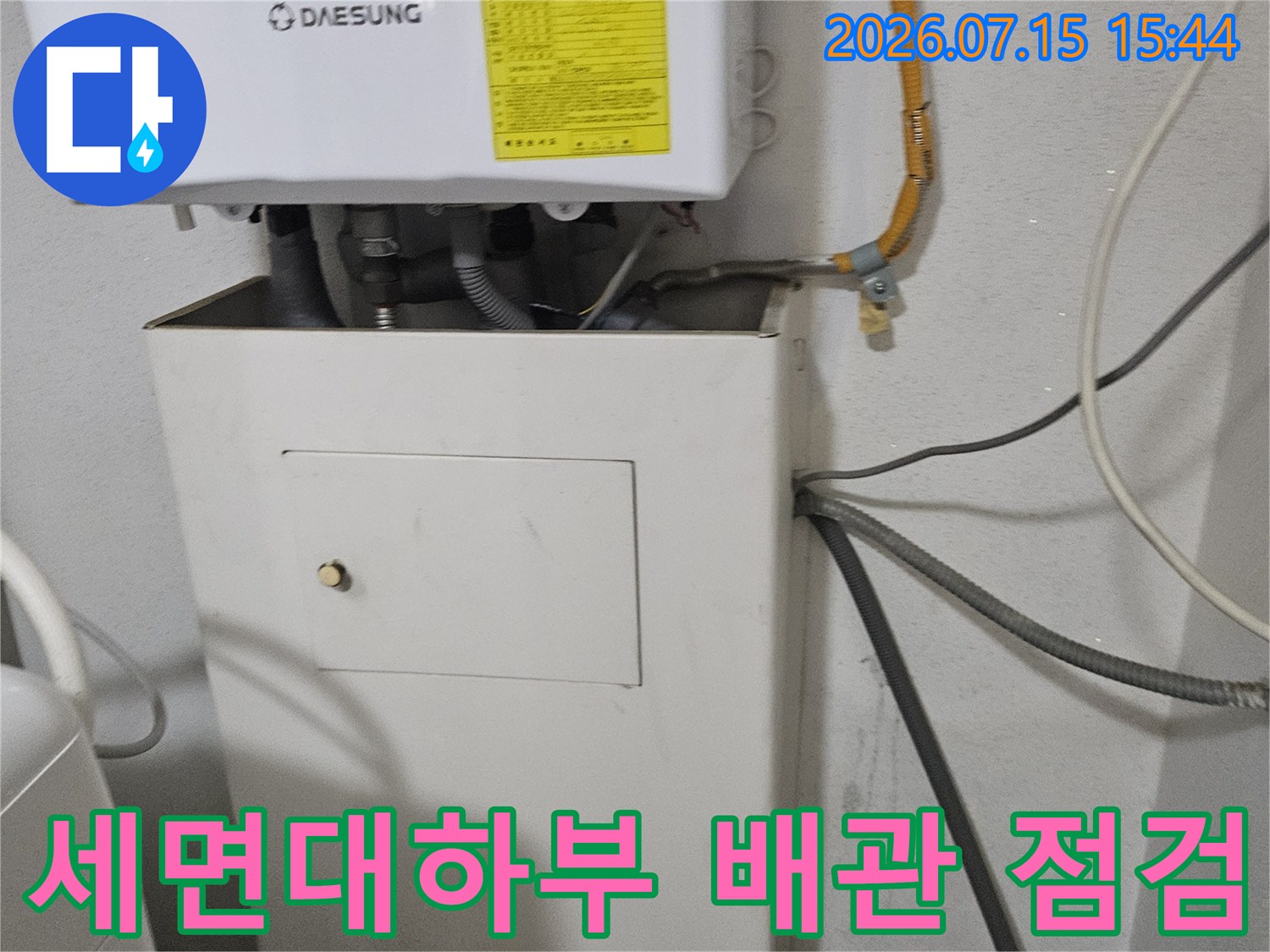 세면대 아래 노출된 배관과 누수 방지용 보호 덮개가 설치된 모습