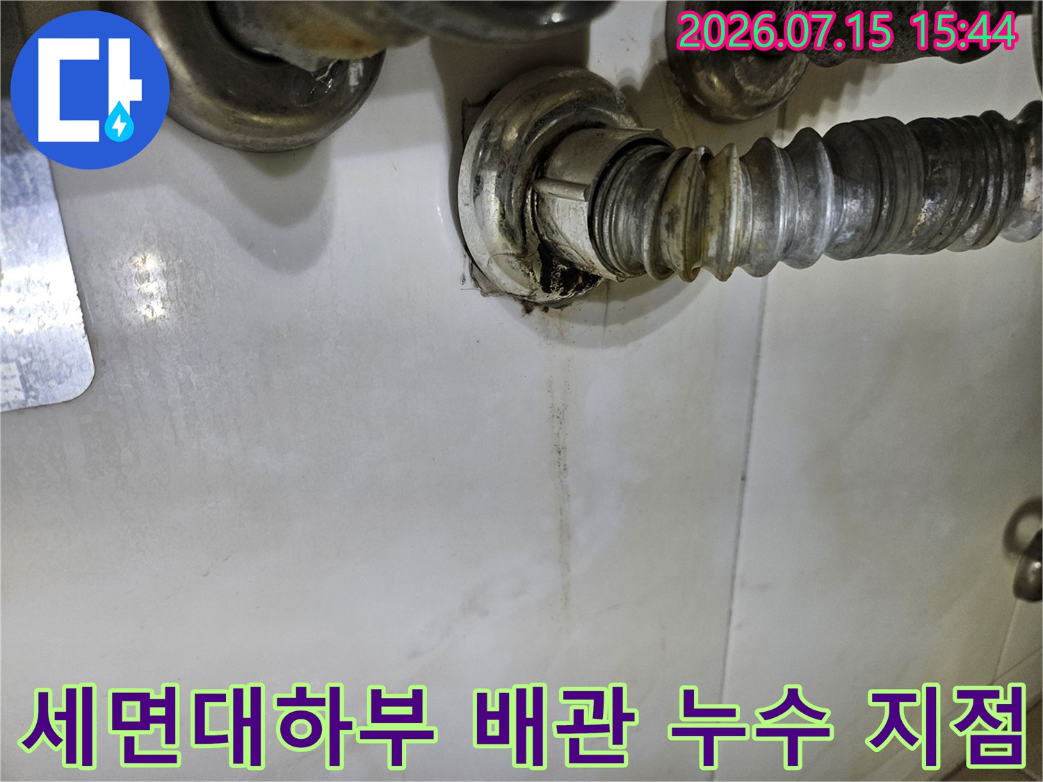 세면대 아래쪽 연결 부위에서 물이 새어 나와 벽면에 자국을 남긴 노후된 배관 상태