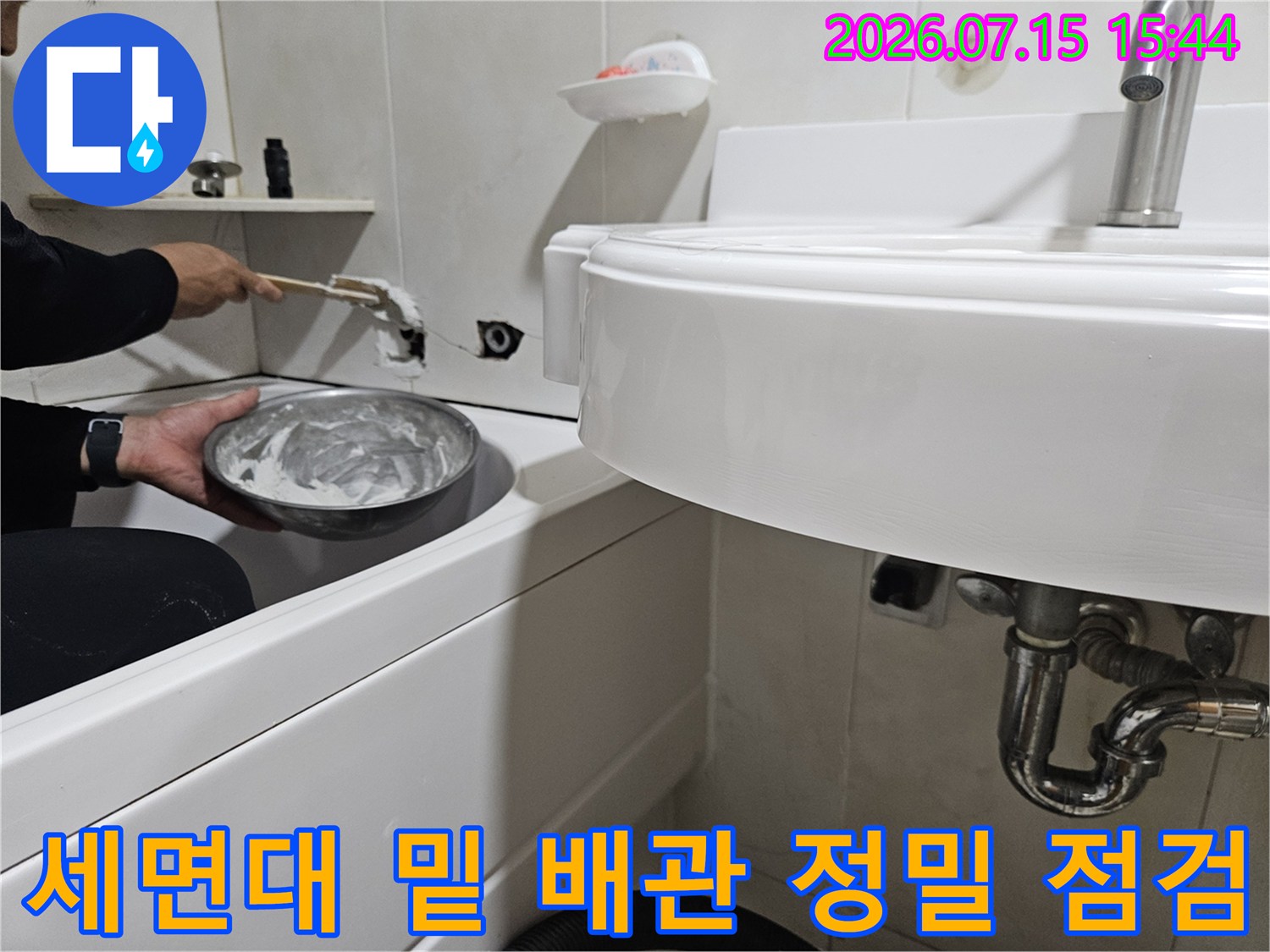 욕실 세면대 하단에 노출된 배관을 손으로 만지며 누수를 체크하는 과정