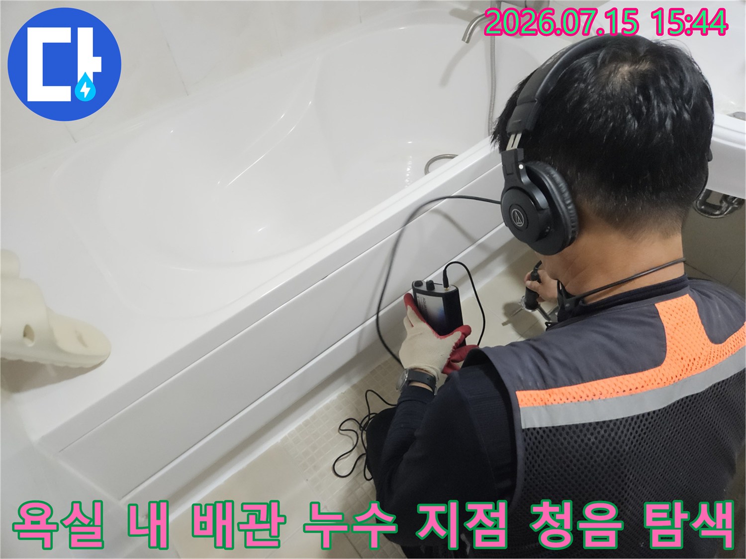 청음 장비를 사용하여 세면대 아래쪽 배관의 누수 위치를 정밀하게 파악하는 장면