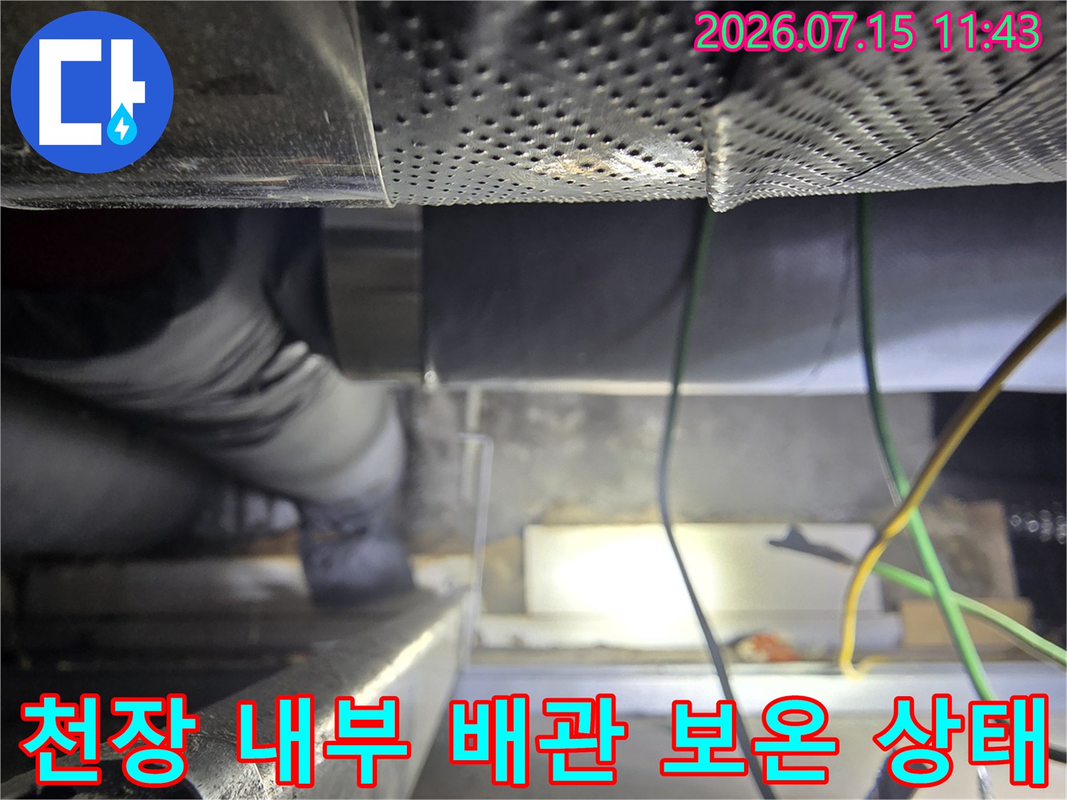 회색-보온재로 마감된 천장 배관과 전기 배선이 얽혀 있는 모습