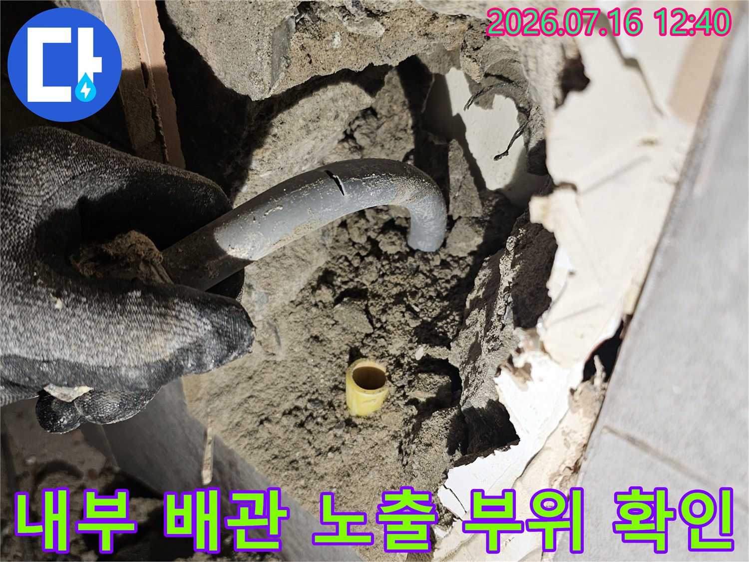 벽면을 파고 들어간 구간에서 흙과 시멘트에 섞인 배관 상태를 면밀히 살펴보는 장면