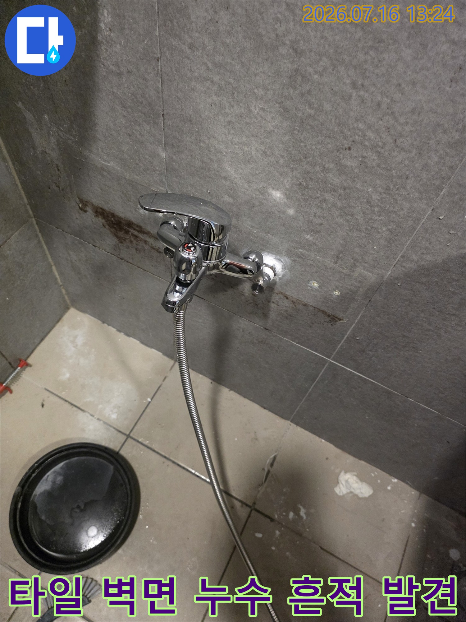 샤워기 수전 주변에 누수로 인한 검은 얼룩과 물때가 발생한 모습