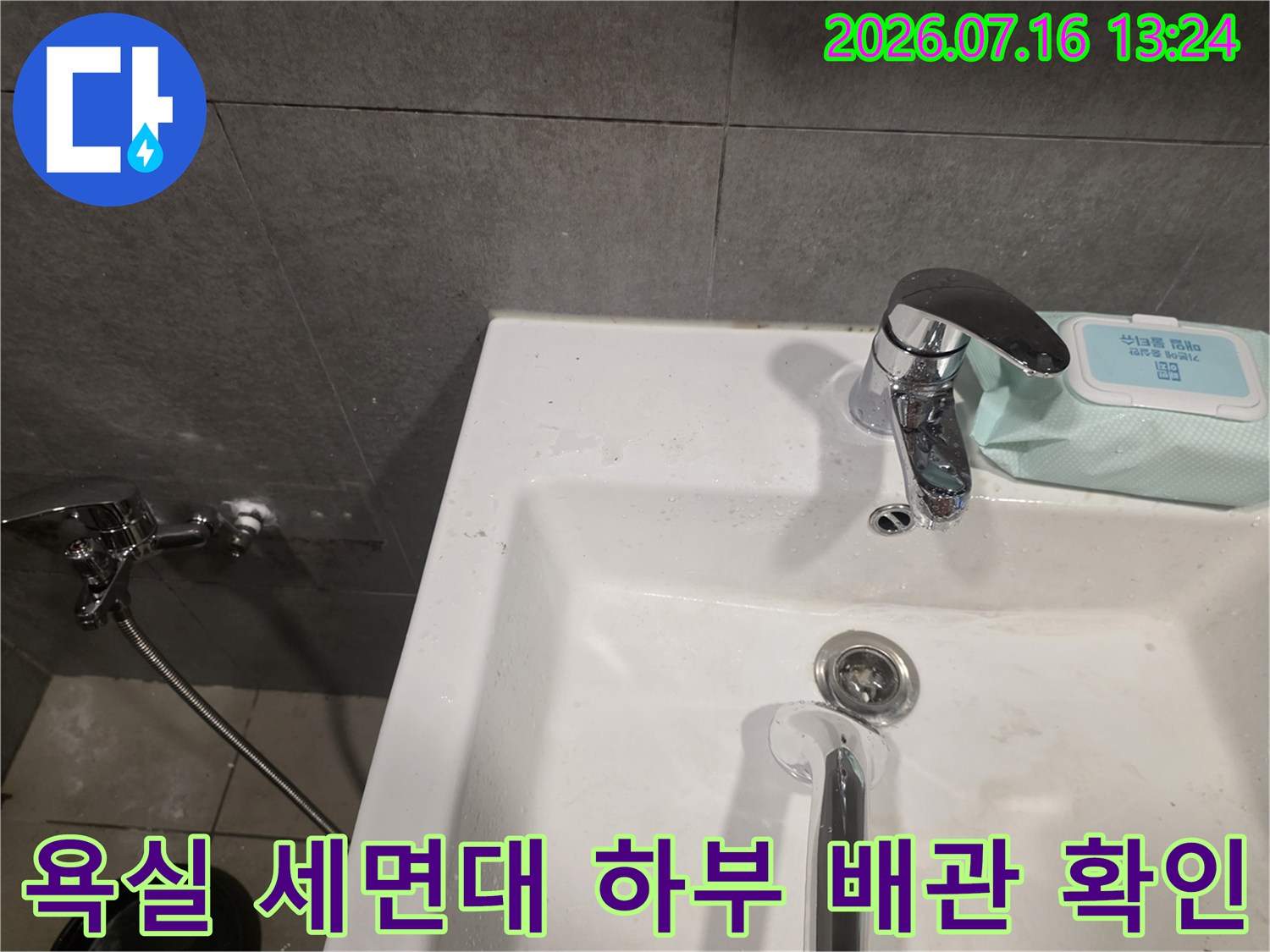 세면대의 밑부분과 연결된 수전 구조를 정밀하게 점검하는 과정
