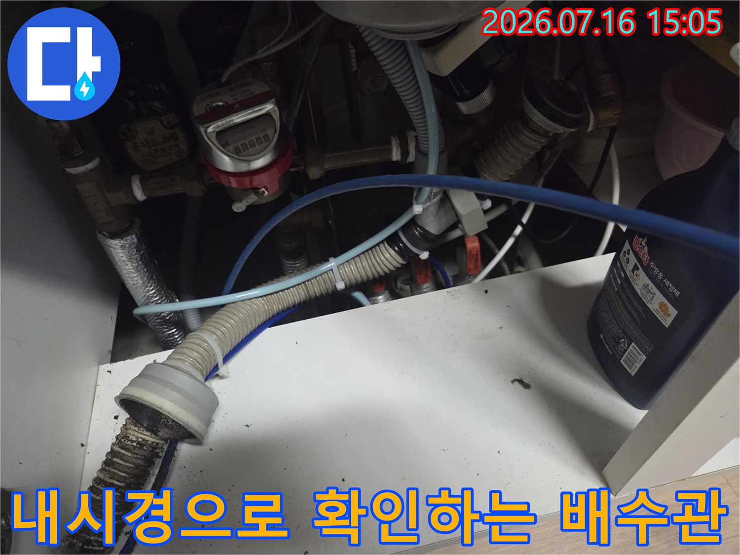 내시경 장비를 투입하여 싱크대 아래 배수관 내부를 점검하는 모습