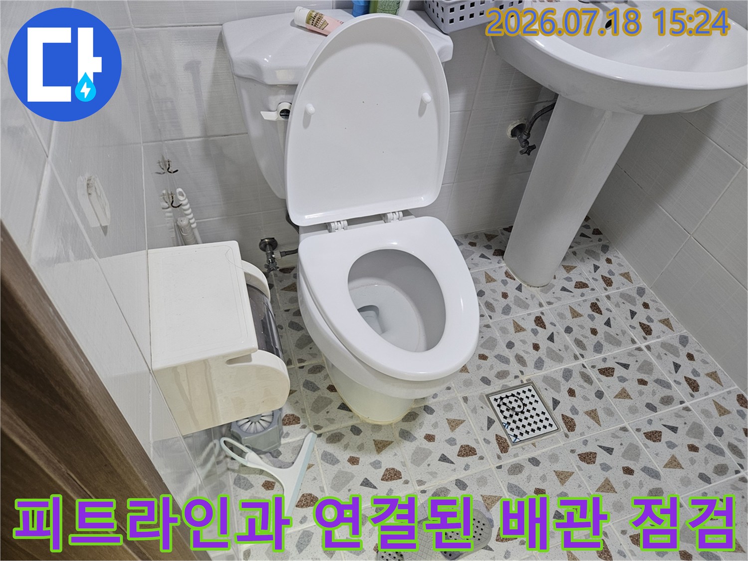 변기 옆쪽으로 노출된 수직 및 수평 배관을 내시경 장비로 정밀하게 검사하는 모습