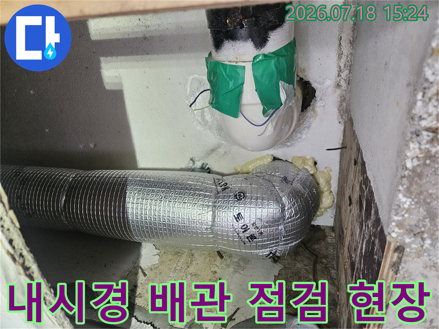 보온재로 감싸진 수직 배관과 내시경 검사를 위한 상부 공간 확인