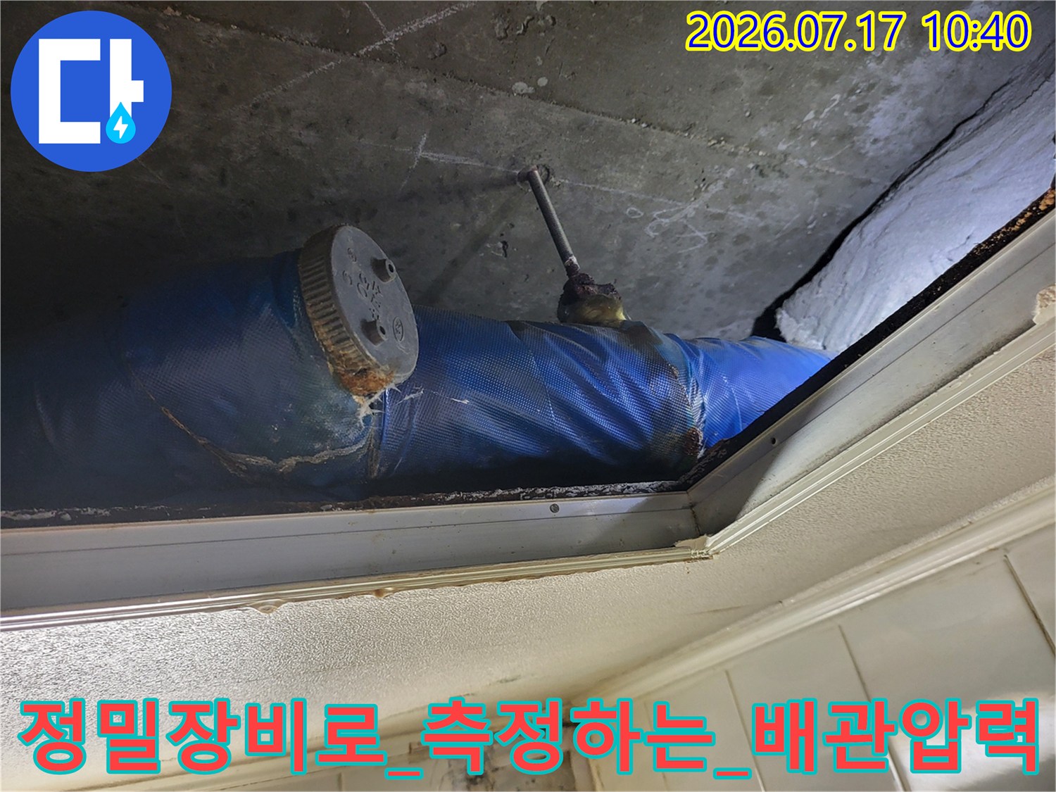 파란색 배관 단열재와 연결된 게이지를 통해 누수 여부를 정밀하게 측정하는 장면