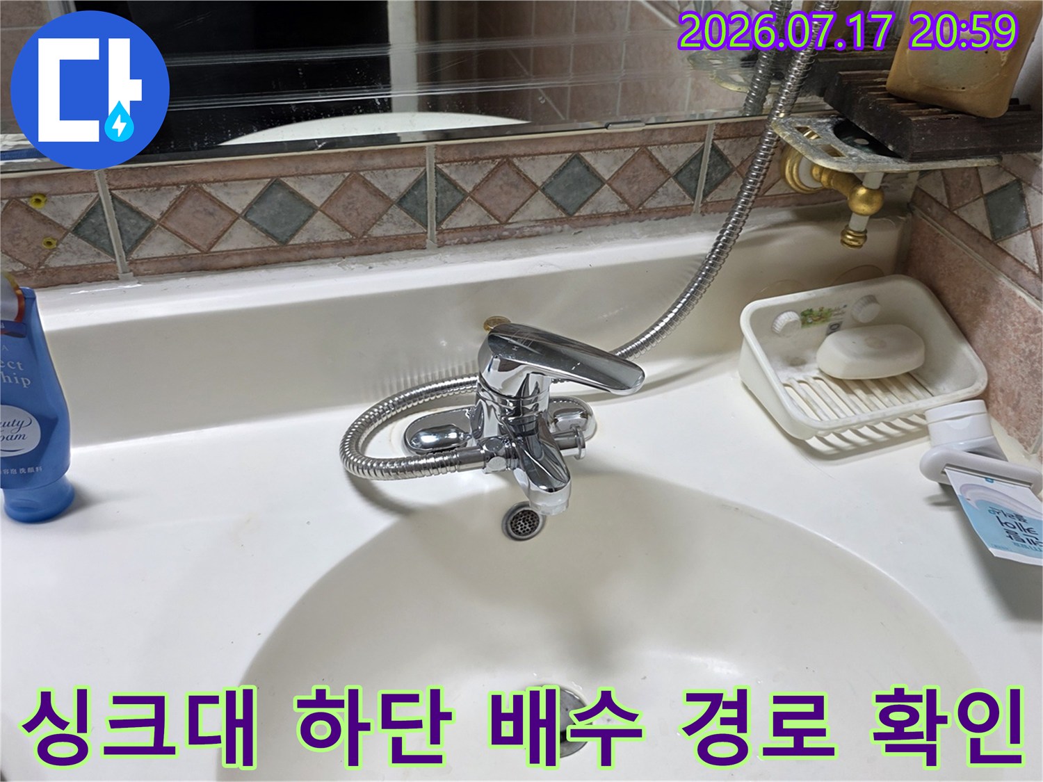 싱크대 아래의 굴곡진 호스와 배수관 연결부 점검 장면